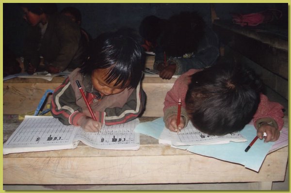 Vorschueler malen tibetische Buchstaben in ein Uebungsheft.jpg
