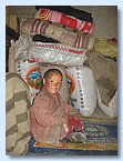 Butti Gurung sitzt vor Saecken mit Waren aus Tibet.JPG