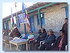 Schulgruender Karma Dhondup haelt eine Rede, Rektor Gyanu Gurung blickt skeptisch.JPG